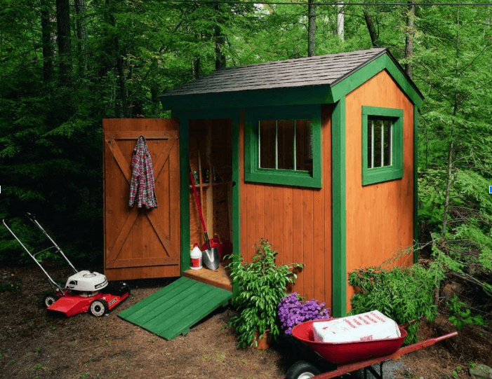 A wooden tool shed with orange siding and green trim