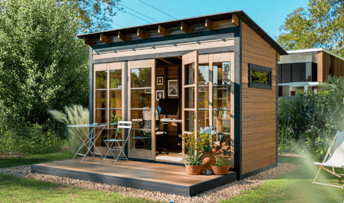 A wooden garden shed with large glass doors and windows