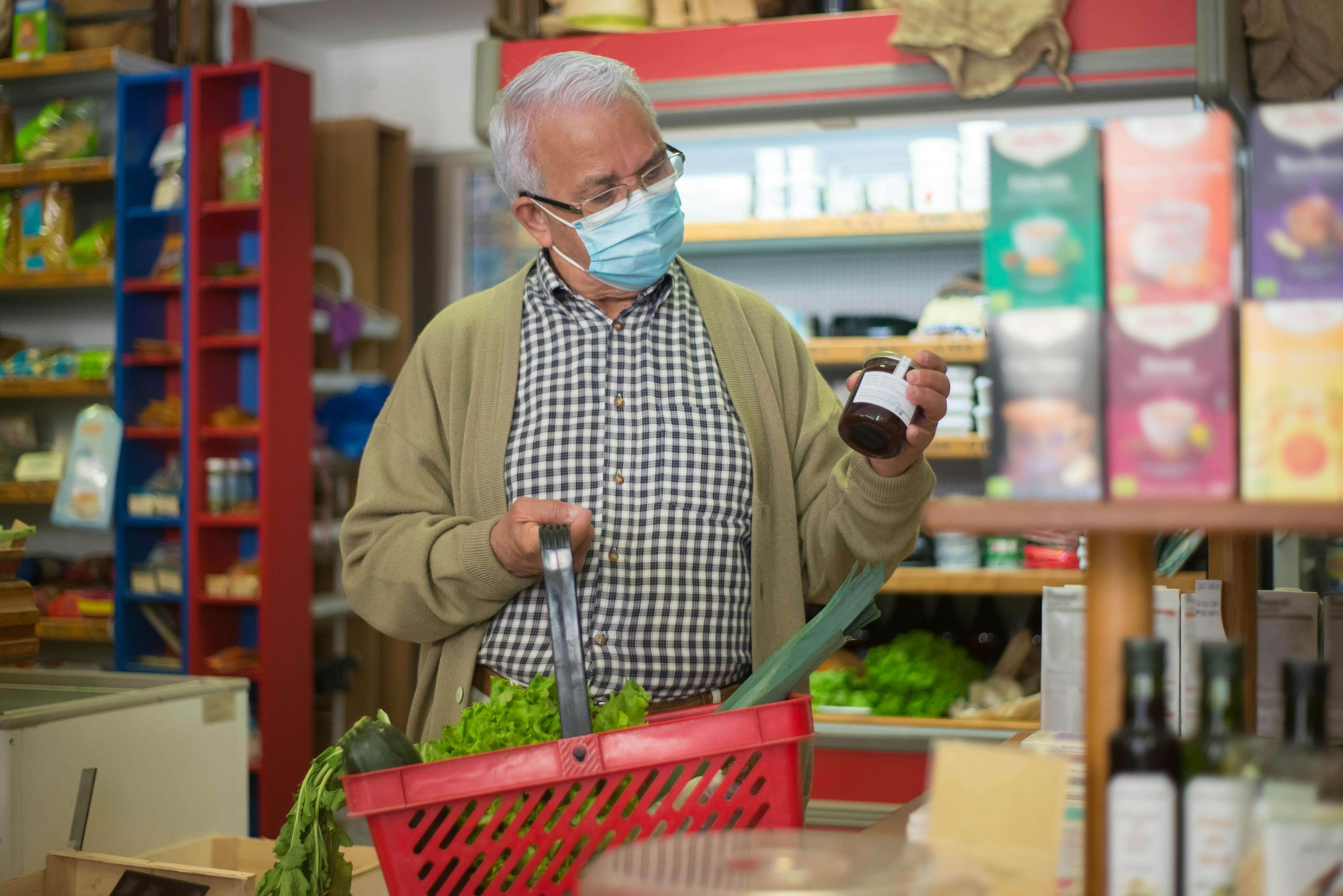 Elderly man shopping for healthy ingredients to manage enlarged prostate symptoms naturally.